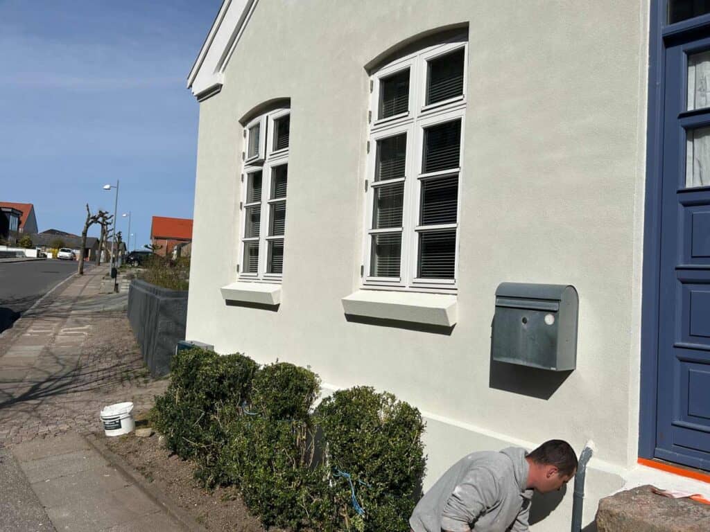 To sprossevinduer i lys murstensvæg renoveret af murer i Egå