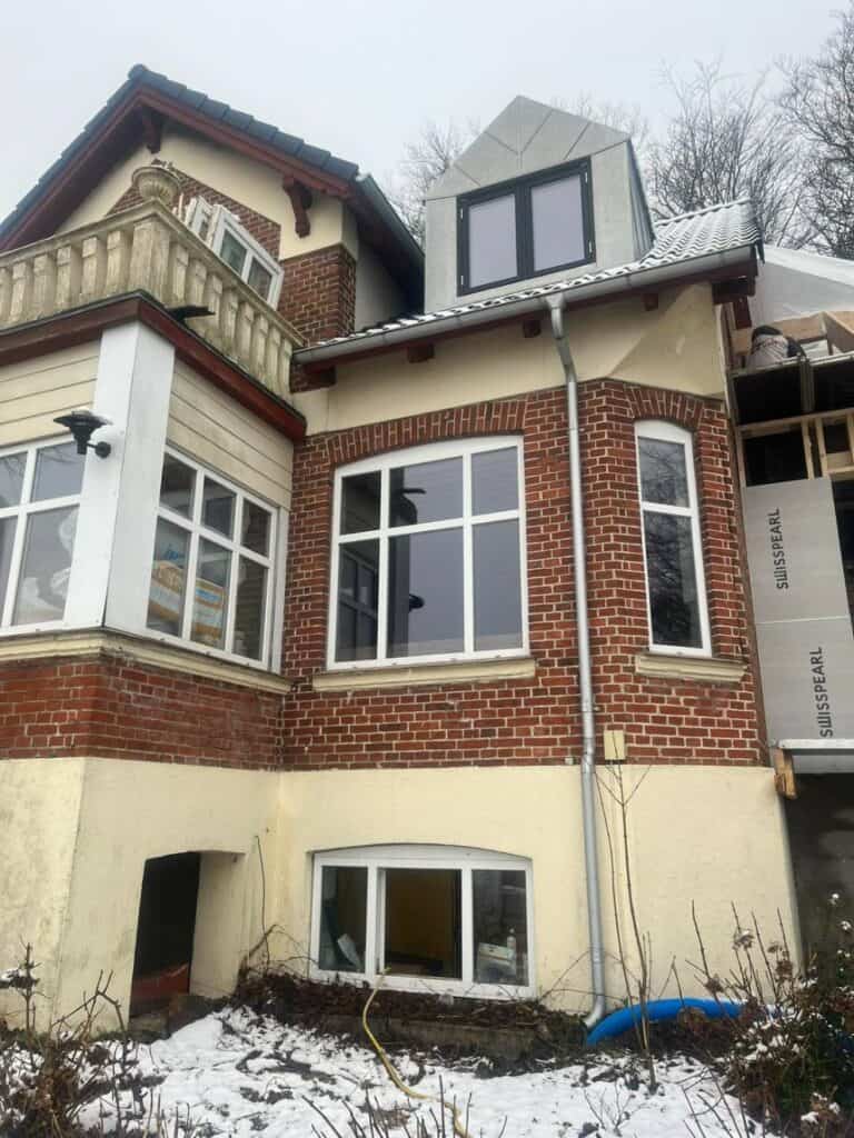 Stor flot bygning med rød tegl og tårn efter facaderenovering i Århus