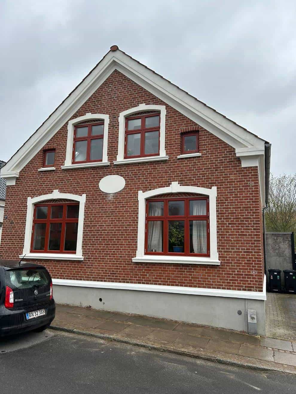 Rød gavl med fire hvide vinduer repareret af murermester i Skanderborg