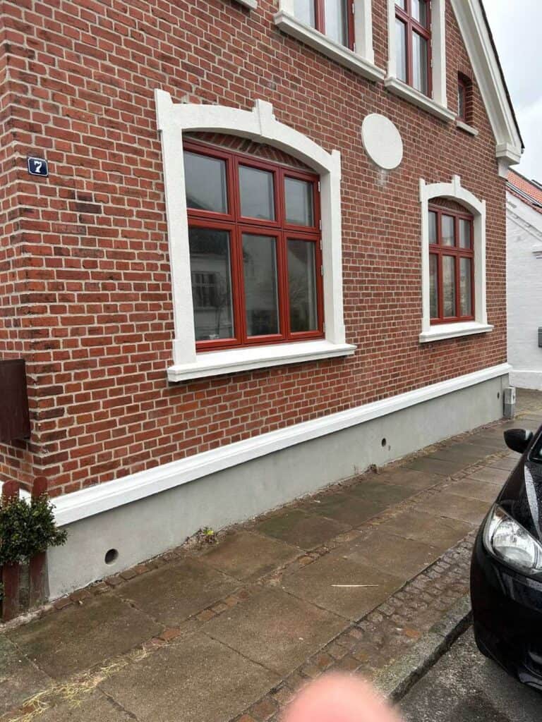Rød gavl med dannebrogsvindue efter udskiftning af fuger i murværk